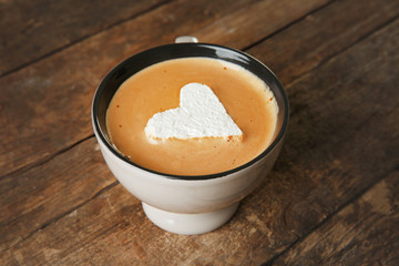 Cup of coffee with marshmallow on wooden table