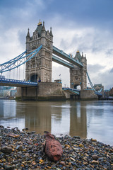 London, UK - The iconic Tower Bridge in the morning with river thames and a red rock