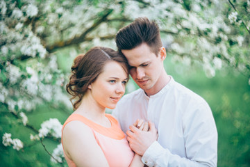 Couple in love under blooming branches spring day.