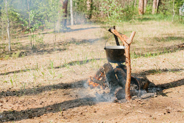 The fire near the camp. Cooking food on a fire. Journey into the wild concept.
