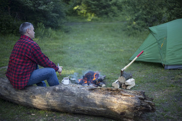 Man cooks the coffee on the fire.