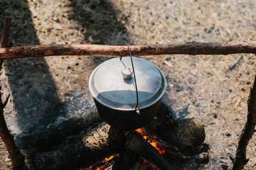 The fire near the camp. Cooking food on a fire. Journey into the wild concept.
