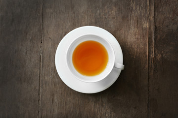 Cup of tea on wooden background, top view