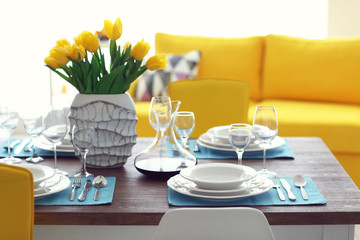 Dining room interior with sofa and table served for dinner