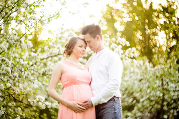 Couple in love under blooming branches spring day.