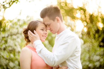 Couple in love under blooming branches spring day.
