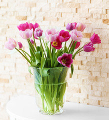 Bouquet of beautiful tulips on brick wall background