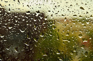 Fototapeta Krople deszczu na szybie, w tle rozmyte domy obraz