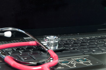 rotes Stethoskop auf Laptop