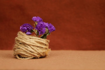 decorative composition of twine and flowers on a brown background