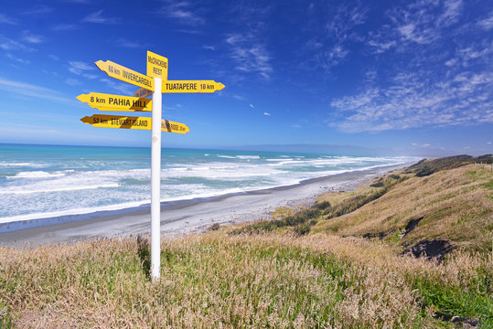 Signpost by the ocean, New Zealand