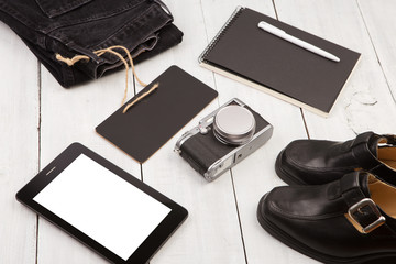 shoes, jeans, tablet pc, camera, notepad and chalkboard on white