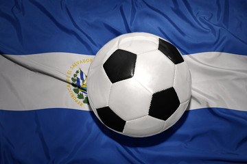 Naklejka premium black and white football ball on the national flag of el salvador