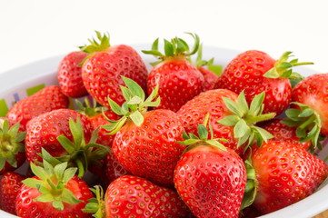 Fresh strawberries in a bowl against white background
