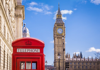 Traditional red british telephone box and Big Ben at Parliament Square with blue sky and clouds -...