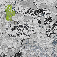Cracked grey wall with green, black and blue layers of paint. Vintage grunge background.