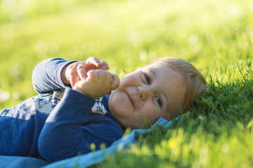 Smiling cute baby laying on the grass