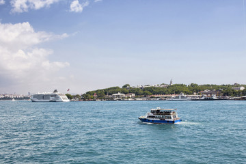 Fototapeta na wymiar Tour boat passes in front of Topkapi palace in Istanbul