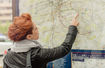 Female tourist looking at public street map