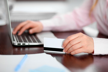 Fototapeta premium Close up of business woman hands using credit card and laptop computer