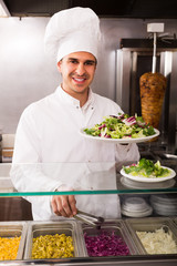 Happy male chef with vegetables