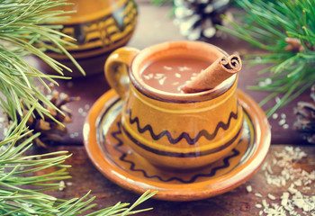 Obraz na płótnie Canvas Hot chocolate with cinnamon in a rustic ware