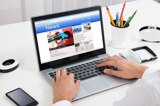 Person Reading News On Laptop