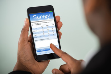 Businesswoman Filling Online Survey On Mobile Phone