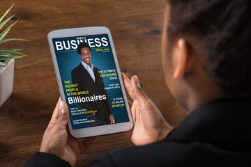 Businesswoman Reading Online Magazine On Digital Tablet