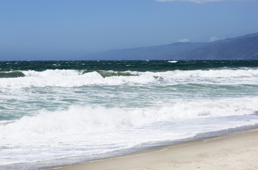 The waves of the Pacific ocean, the beach landscape. The ocean, mountains and blue sky in USA, Santa Monica. 