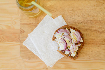 Fototapeta na wymiar toast with onion feta oregano on a wooden cutting board with apple juice in the bank