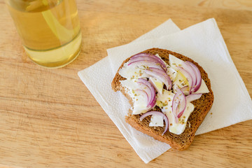 toast with onion feta oregano on a wooden cutting board with apple juice in the bank