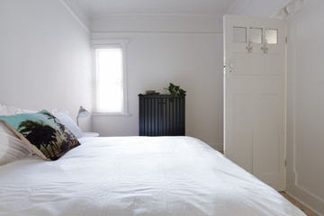 Monochrome bedroom with decorator cushion in white interior