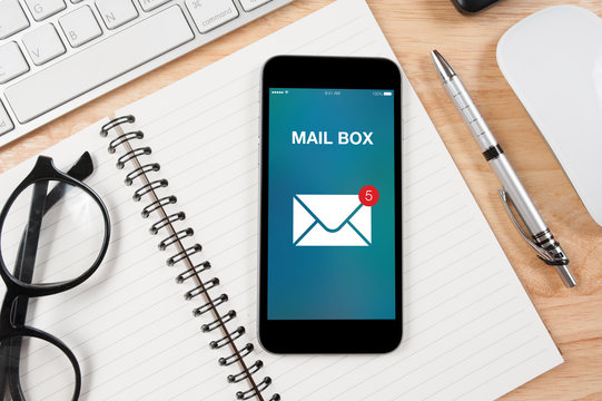 Concept mobile email screen with office supplies on the table