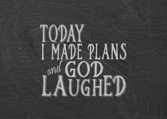humorous quote about making plans on dusty black chalkboard