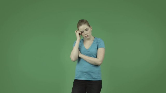attractive thinking worried caucasian casual girl isolated on green