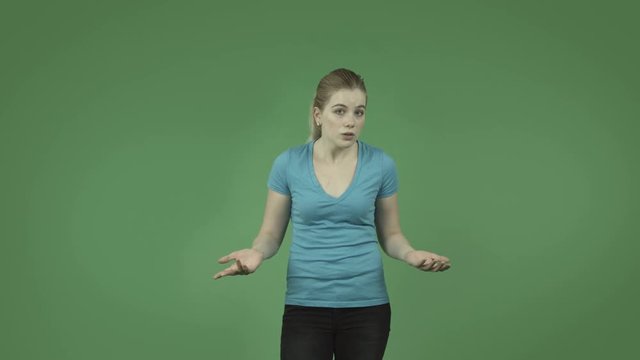 attractive caucasian casual girl upset and talking isolated on green