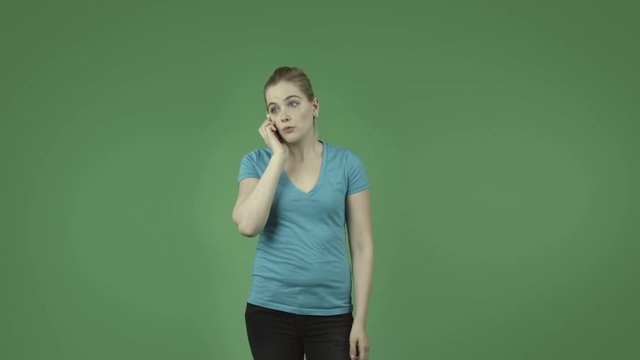 attractive caucasian casual girl isolated on green upset with cell phone