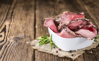Old wooden table with sliced Roastbeef