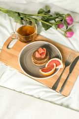 Breakfast in bed, Oatmeal pancakes with grapefruit, tea and Peon