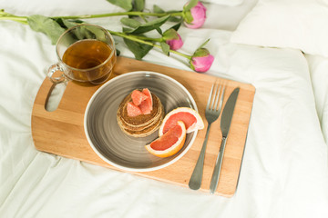 Breakfast in bed, Oatmeal pancakes with grapefruit, tea and Peon