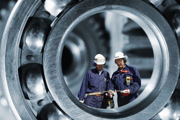 industrial engineering parts with two workers inside giant ball-bearing