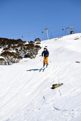 Fototapeta na wymiar Skier racing and jumping through a Ski Cross Course - racing against the clock in the Australian Alps.