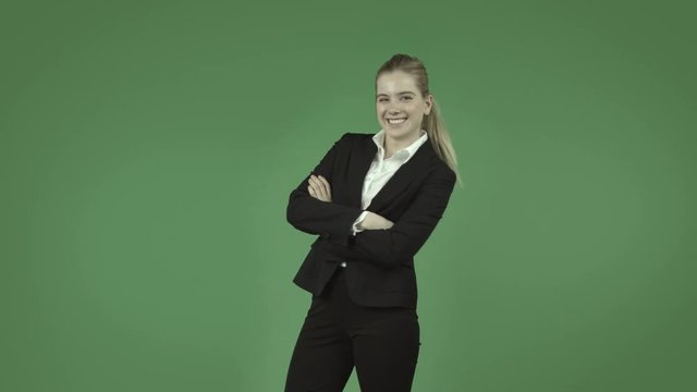 attractive caucasian business girl isolated on green with happy dance