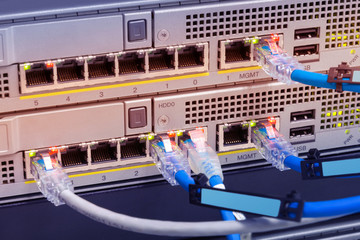 Closeup network cables connected to switches server computer with abstract color effect.