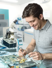 Tech or engineer repairs electronic equipment in research facili