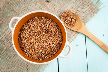 Buckwheat groats in a bowl and wooden scoop