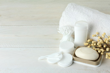 Fototapeta na wymiar personal hygiene items with decorative sprigs on a white wooden background