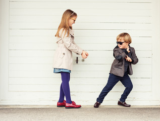 Fashion kids outdoors, wearing jackets and sunglasses