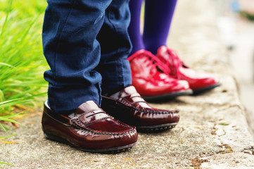 Two pairs of kids feet wearing fashion shoes